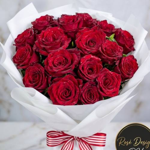 Fresh red rose bouquet wrapped in white paper for delivery in Lahore by RoseDesign.pk.